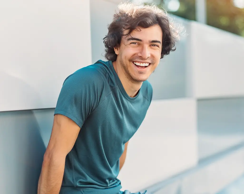 Young man in sports wear having a rest at sunlight, with copy space